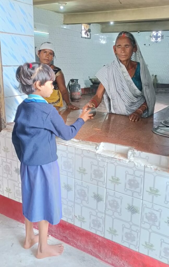 Une personne âgée participe à la distribution du repas.